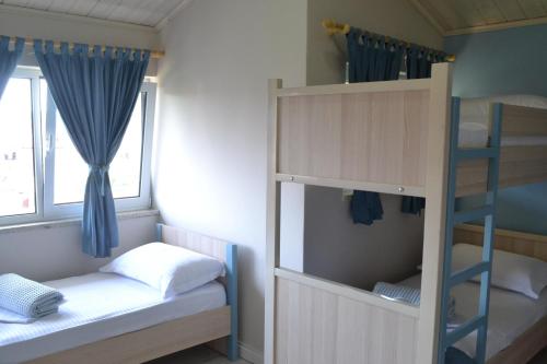 a bedroom with two bunk beds and a ladder at Open Doors Bed & Breakfast in Shkodër