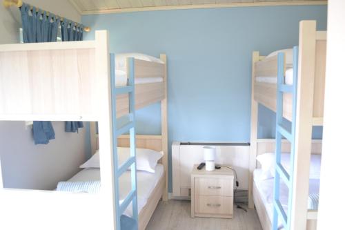 two bunk beds in a room with a lamp at Open Doors Bed & Breakfast in Shkodër