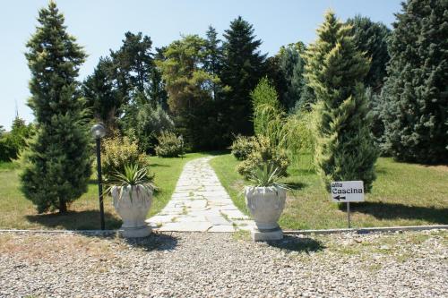 a garden with two potted trees and a path at Tenuta Terensano in Monleale