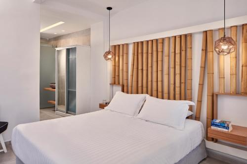 a bedroom with a large white bed with white pillows at Callia Retreat Suites - Adults Only in Fira