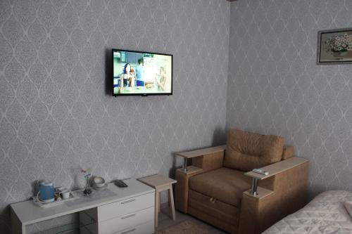 um quarto com uma cama e uma televisão na parede em Мини отель,Хостел Кенгуру em Umanʼ
