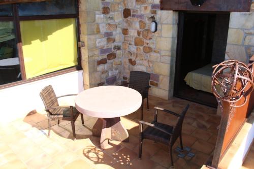 a patio with a table and chairs and a bed at Agroturismo Maddiola in Donostia-San Sebastián