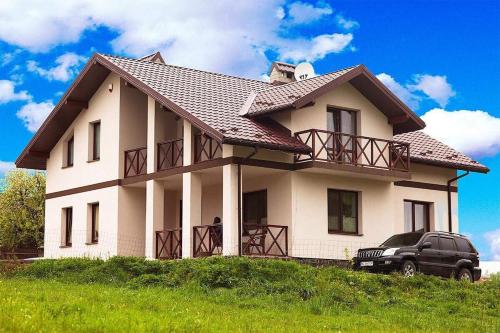 a house with a black truck parked in front of it at Карпатский уикенд in Slavske
