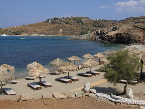 a beach with chairs and umbrellas and the water at Unique studio by the sea in Koundouros