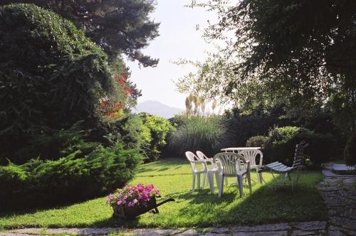 two white chairs and a table in a garden at Tenuta Terensano in Monleale
