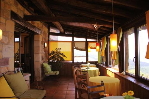 a dining room with tables and chairs and windows at Agroturismo Maddiola in Donostia-San Sebastián