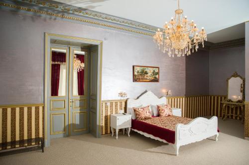a bedroom with a bed and a chandelier at NF Palace Old City Bucharest in Bucharest