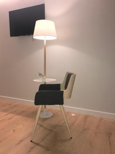 a table with a chair and a lamp in a room at IXUA Hotela in Éibar