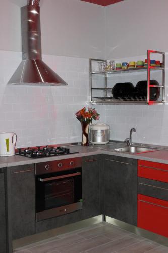 a kitchen with a stove top oven next to a sink at Мини отель,Хостел Кенгуру in Umanʼ