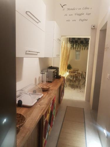 a kitchen with a counter and a table with chairs at Bed Nonnonino in Porto Cesareo