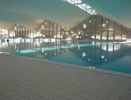 une grande piscine dans un grand bâtiment dans l'établissement Deauville Triangle d OR, à Deauville