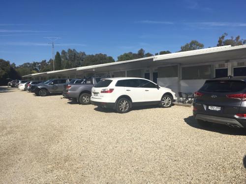 a row of cars parked in front of a trailer at Byer Fountain Motor Inn in Holbrook