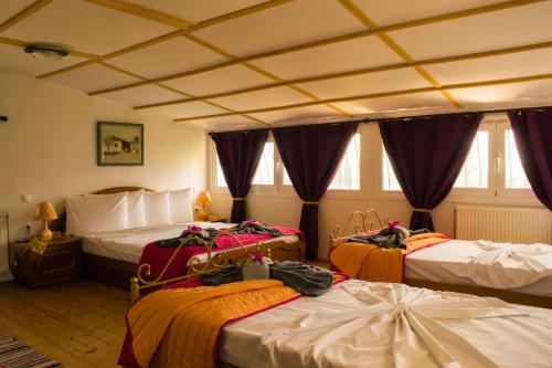 um quarto com três camas com cobertores em Happy Owl Village em Zakynthos