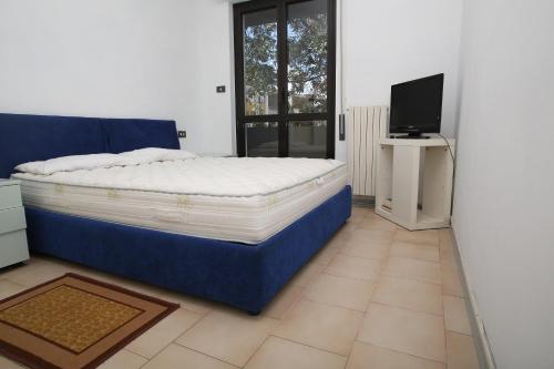 una camera con un grande letto e una televisione di Residence Le Palme a Montesilvano