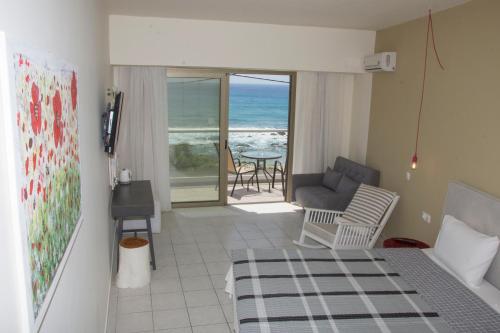 a bedroom with a bed and a view of the ocean at Creta Mare Hotel in Plakias