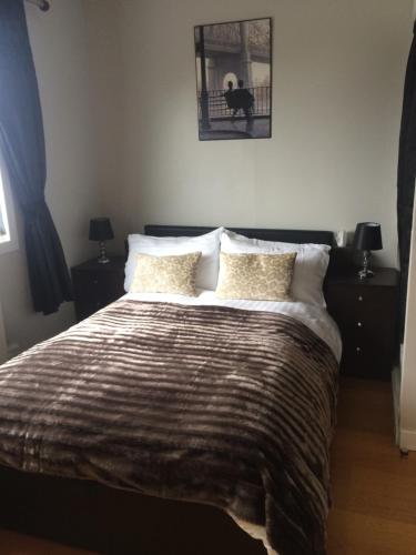 a bedroom with a bed with a blanket and pillows at Lochalsh View en suite Kyle near Skye in Kyle of Lochalsh