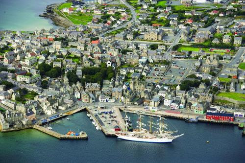 an aerial view of a harbor with a boat in the water at 16 Mounthooly Street in Lerwick