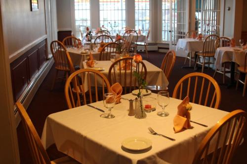 un comedor con mesas y sillas con mantel blanco en The Tilton Inn, en Tilton