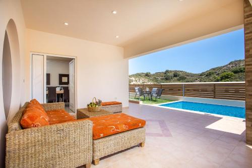 een woonkamer met een bank en een zwembad bij MeFoMi Villa in Rhodos-stad