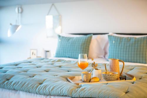 a tray with a glass of wine and a tray of food on a bed at IXUA Hotela in Éibar