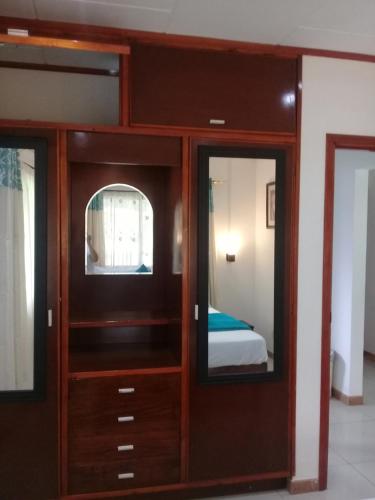 a room with a wooden cabinet with two mirrors at Agnes Cottage in La Digue