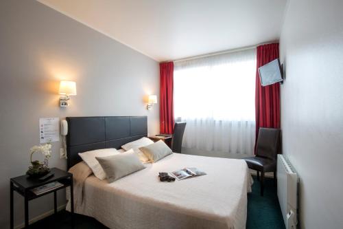 une chambre d'hôtel avec un lit et une fenêtre dans l'établissement Bristol Logis Cit'Hotel Périgueux Centre, à Périgueux