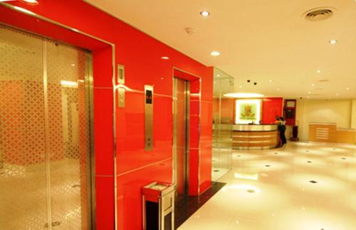 a lobby with a red wall and a glass door at Hotel Imperial in Kuala Lumpur