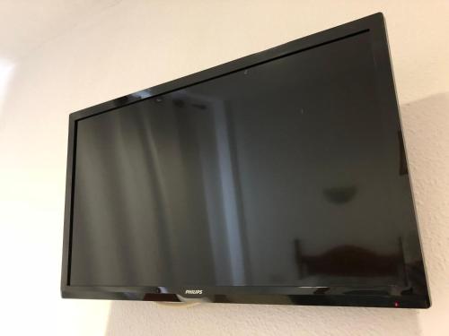 a flat screen tv hanging on a wall at Hostal 82 in Olías del Rey