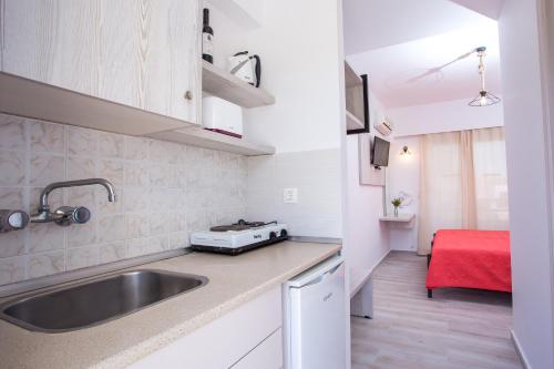 a kitchen with a sink and a red table at Stay Helios in Faliraki