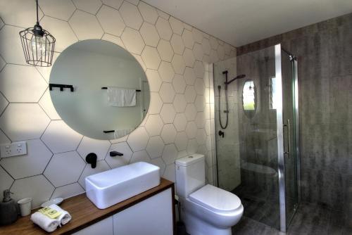 y baño con aseo, lavabo y espejo. en Freycinet Beachfront Retreat, en Coles Bay