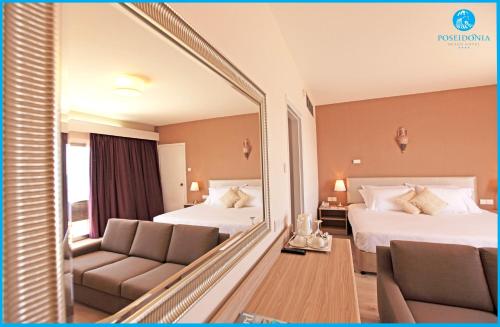 a hotel room with two beds and a mirror at Poseidonia Beach Hotel in Limassol