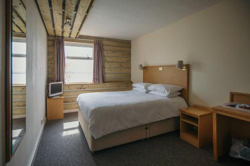 a small bedroom with a bed and a television at Royal Hotel, Bar & Grill in Purfleet