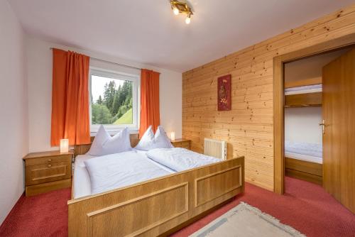 ein Schlafzimmer mit einem großen Bett und einem Fenster in der Unterkunft Ski- und Wander Appartements Schiffer in Innerkrems