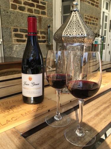 deux verres de vin rouge à côté d'une bouteille de vin dans l'établissement Chateau Anaselle, à Condé-sur-Noireau