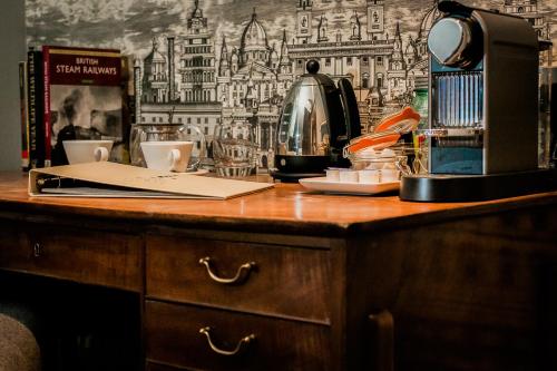 a wooden desk with a coffee maker on top of it at Hand & Flower in London