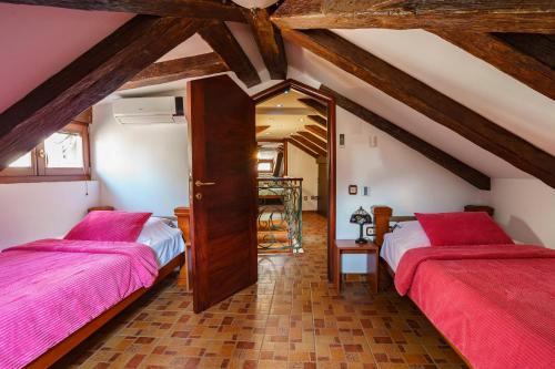 a attic room with two beds and a mirror at Apartments Wine House Old Town in Kotor