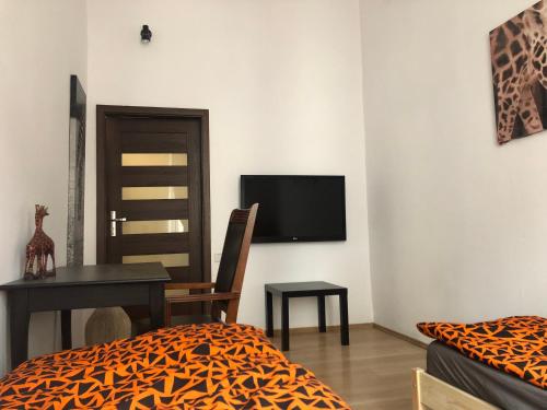 Pokój z łóżkiem, biurkiem i telewizorem w obiekcie GLAMOUR Apartment Florianska 32 w Krakowie