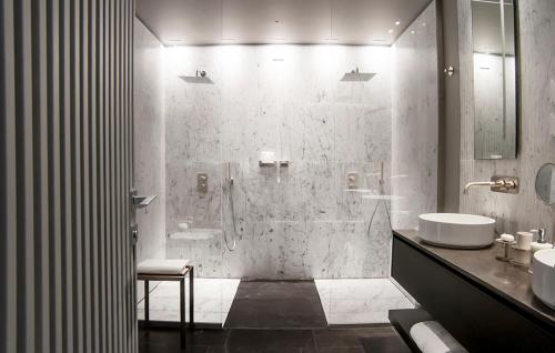 a bathroom with a shower with two sinks and a toilet at Hotel Byron in Forte dei Marmi