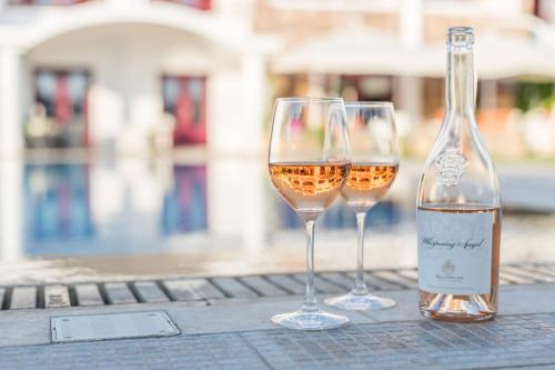 two glasses of white wine sitting on a table at Ariadne Hotel in Agios Prokopios