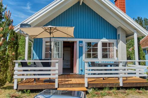 a blue house with two chairs and an umbrella at Useriner Ferienhaus in Userin