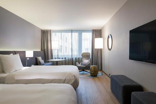 a hotel room with two beds and a flat screen tv at Radisson Blu Hotel, Lucerne in Luzern