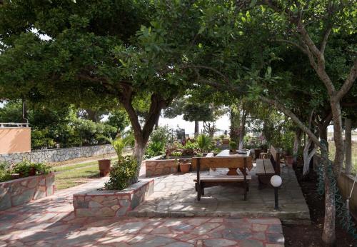 a bench sitting under a tree in a park at House Souzanna in Toroni