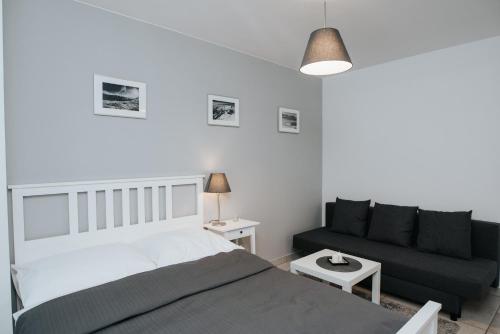 a bedroom with a bed and a couch at Apartamenty Niezapominajka in Poronin