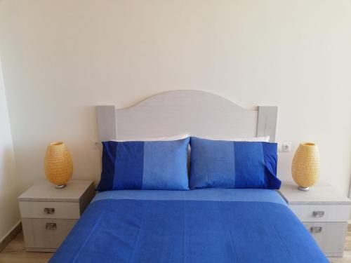トレモリノスにあるCentral Large Studio Torremolinosのベッドルーム1室(青いベッド1台、花瓶2本付)