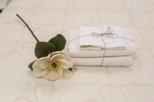 un mucchio di asciugamani e un fiore su un tavolo di Due Passi Suite a Palermo