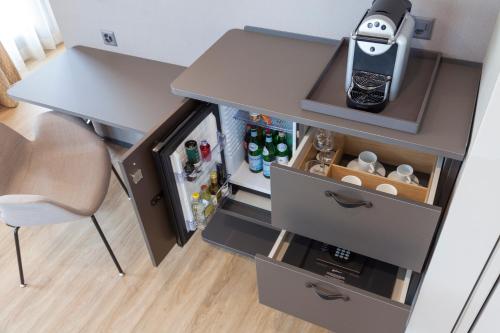 a small kitchen with a desk and an open refrigerator at Radisson Blu Hotel, Lucerne in Luzern