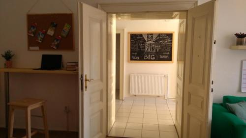 a hallway leading to a kitchen with a chalkboard on the wall at GRAN hostel in Banská Bystrica