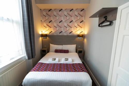a small bedroom with a bed in a room at Euro Hotel in London