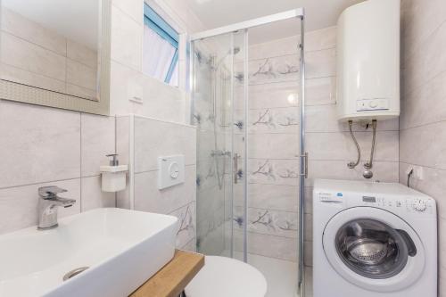 a bathroom with a washing machine and a shower at Vila Saja in Selce