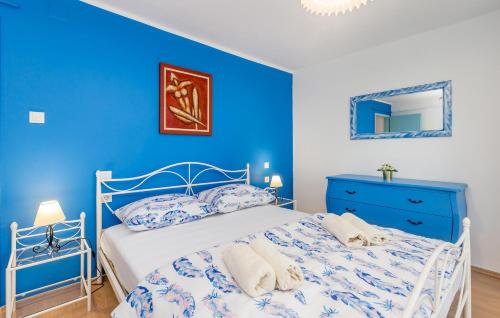 a blue bedroom with a bed and a blue wall at Vila Saja in Selce